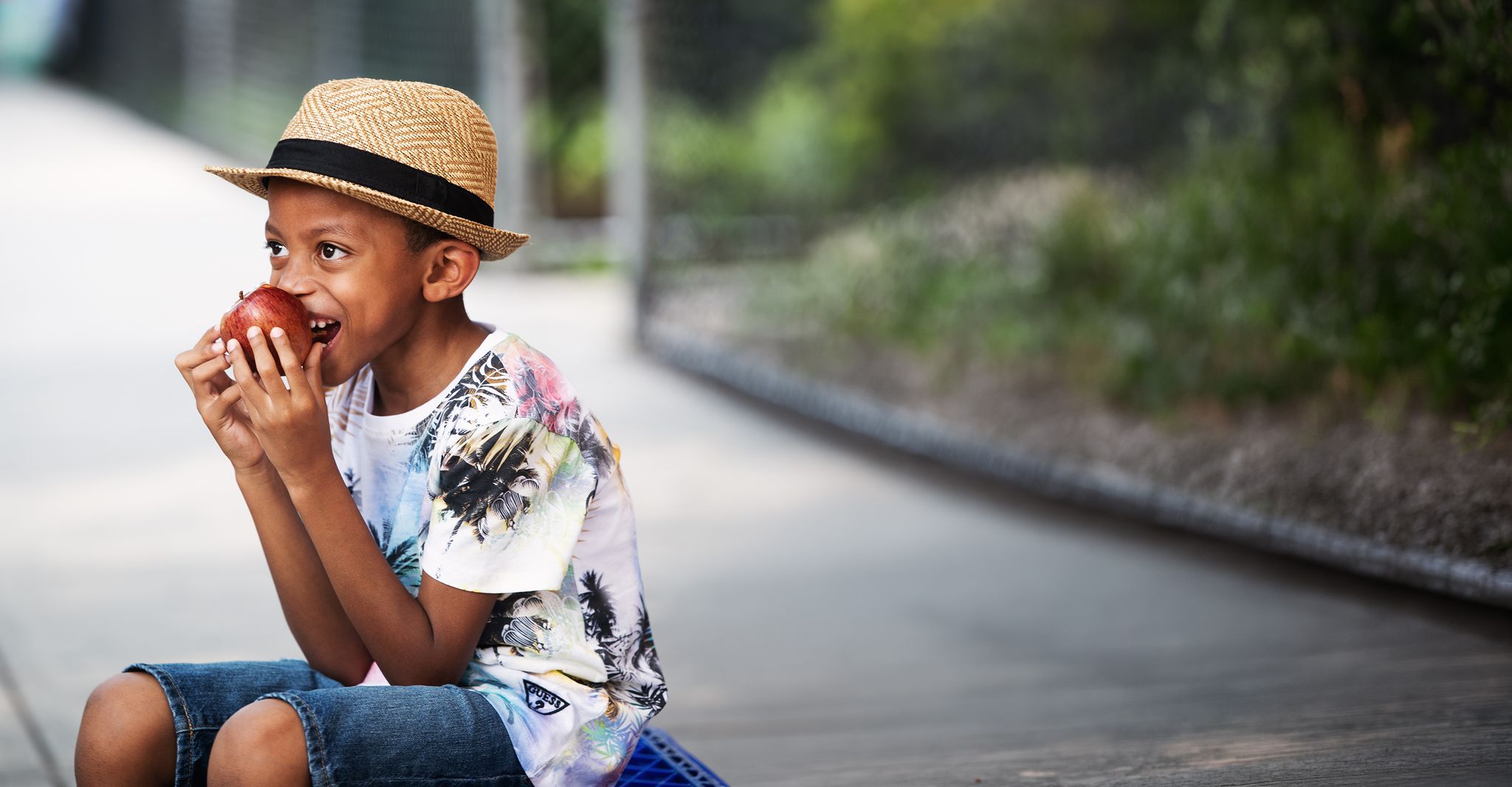 Boy wearing a hat and eating an apple