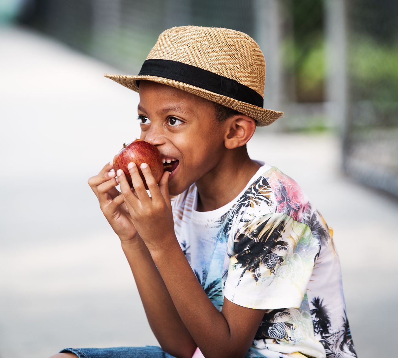 Boy wearing a hat and eating an apple