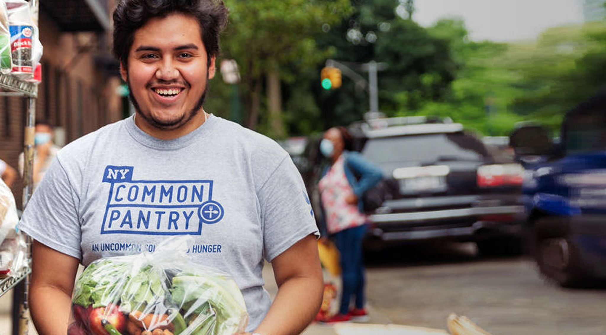 Smiling volunteer holding a bag of produce